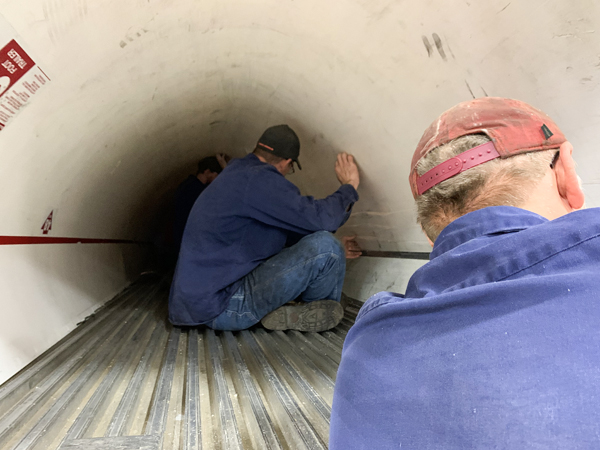 Utility service technicians reinstalling liner after bottom rail replacement.